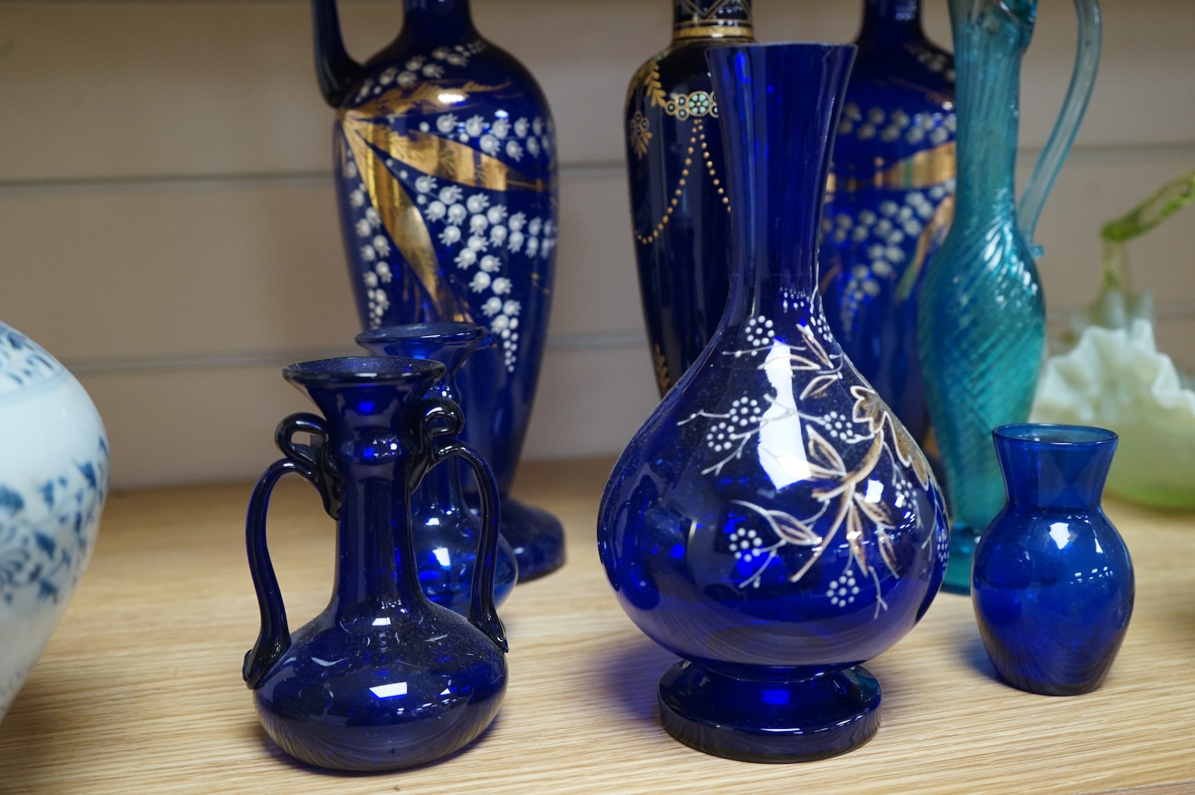 A collection of Bristol blue glassware to include enamel and gilt decanters, together with other glassware, baskets etc, largest 33cm high